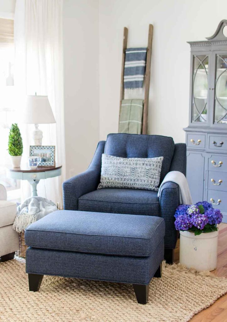 navy blue chair and ottoman in living room with white dove walls