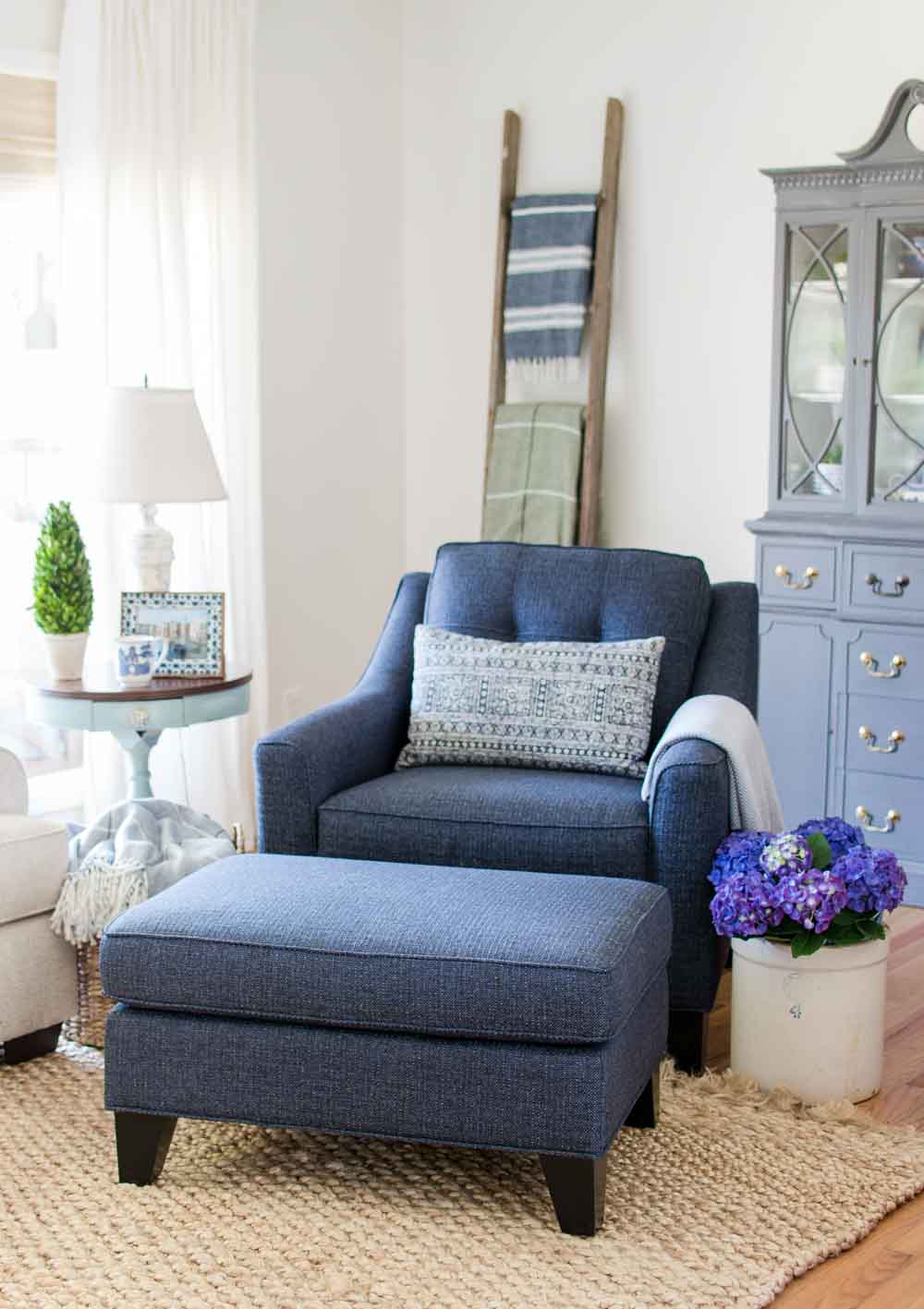 navy blue chair and ottoman in living room with white dove walls